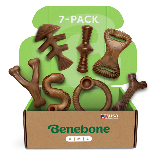 A Benebone Complete Chew Collection (7-Pack) box displays seven durable, uniquely shaped dog chew toys on a green background, highlighting the 7-Pack and featuring a small USA flag icon.