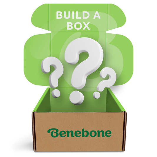 A cardboard Benebone box with a green lid open, showing large 3D question marks inside. The inside of the lid reads BUILD A BOX in white letters. Product: Build a Box: Fi Device by Benebone.