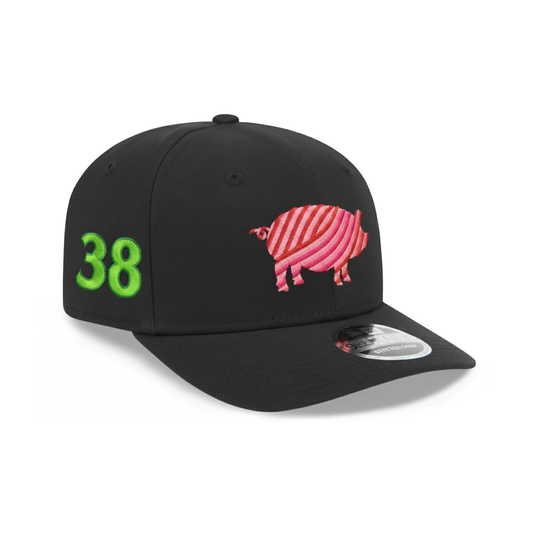 A black Benebone Pig Hat by New Era (9SEVENTY Snapback) features a pink striped pig embroidered on the front, a bright green 38 on the side, curved brim, and a sticker on the bill.