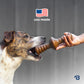 A dog bites a Benebone Limited Edition Chew Collection (4-Pack) held by a person’s hand. Above, a stylized U.S. flag and “USA made” appear. The blurred gray background highlights this durable dog chew toy.