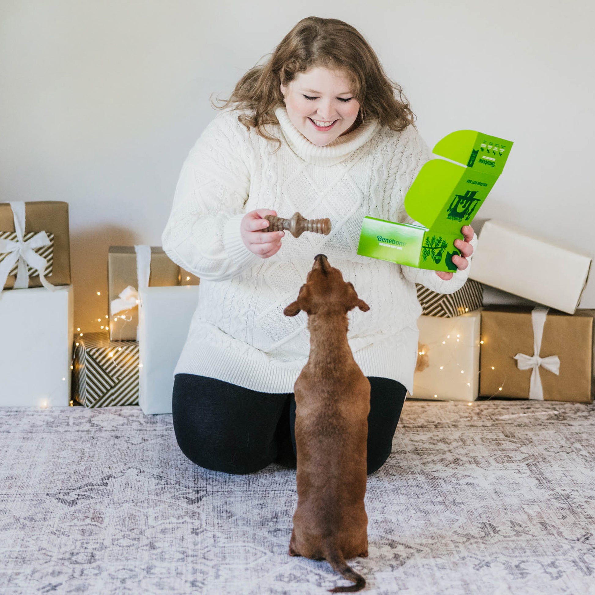 women with Benebone holiday gift box and dog with Benebone