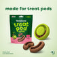 A green Benebone Tongue Twister natural rubber puzzle toy sits next to brown treat pod refills and green treat pod refills. Text says “Made for Treat Pods.” Treat pods are sold separately, making this an ideal choice for dog enrichment.