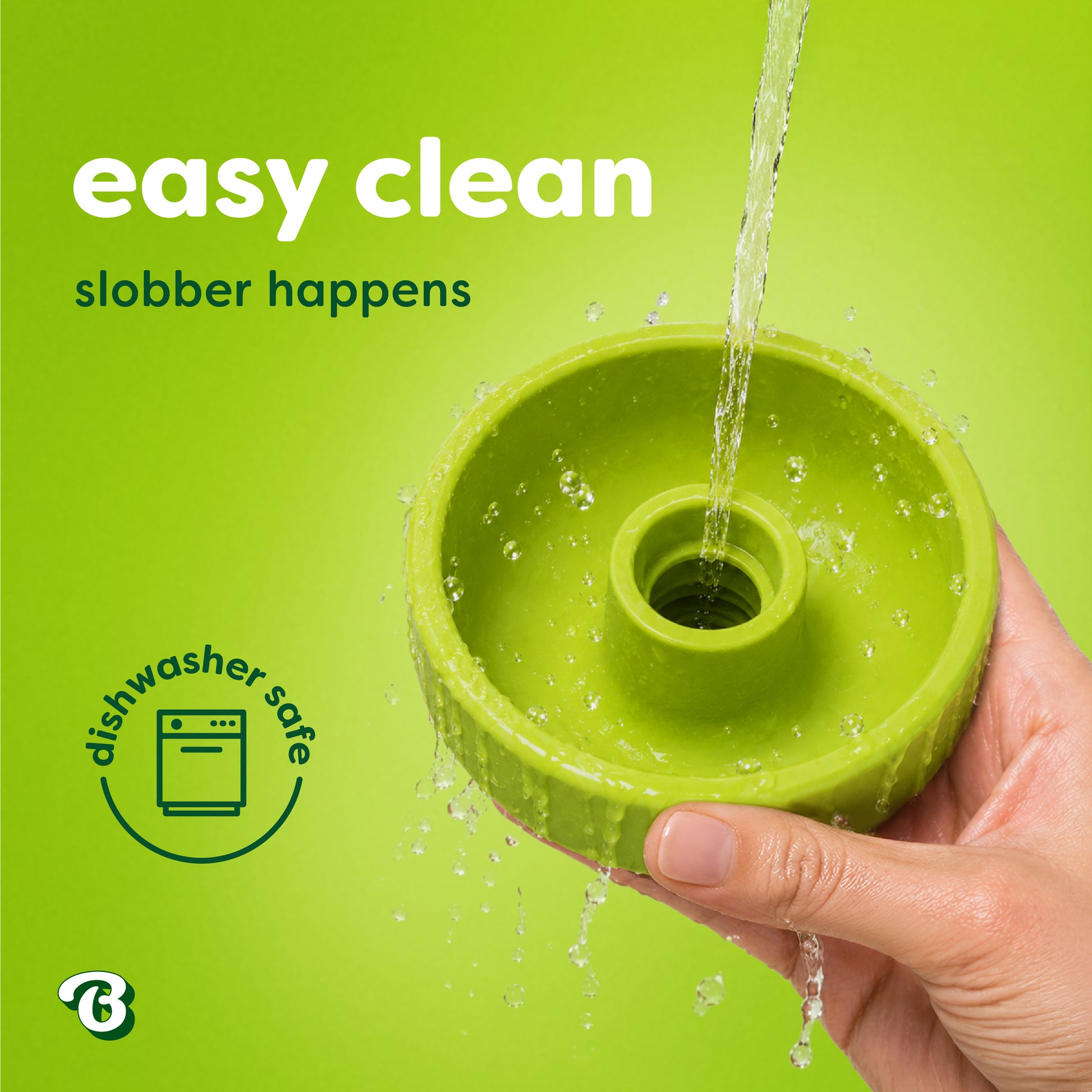 A hand holds a green Benebone Tongue Twister natural rubber puzzle toy under running water. Text reads easy clean, slobber happens and a dishwasher safe icon is shown. Perfect for dog enrichment, the background is bright green.